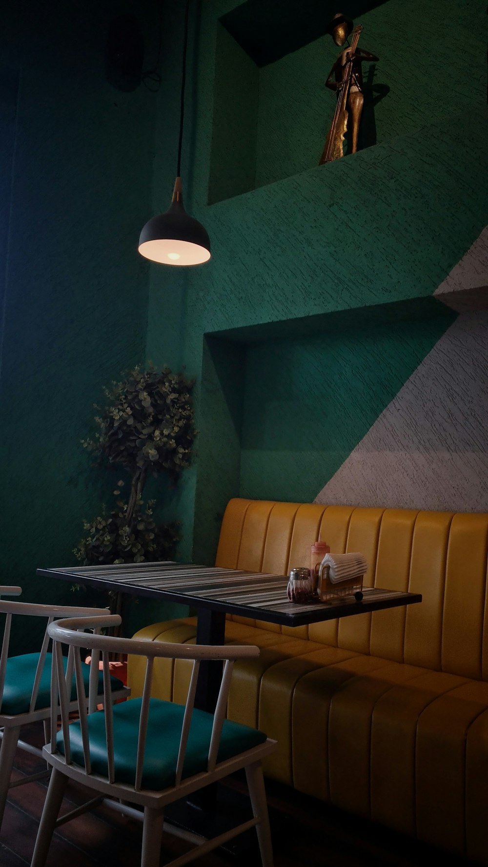 a table and chairs in a room with green walls