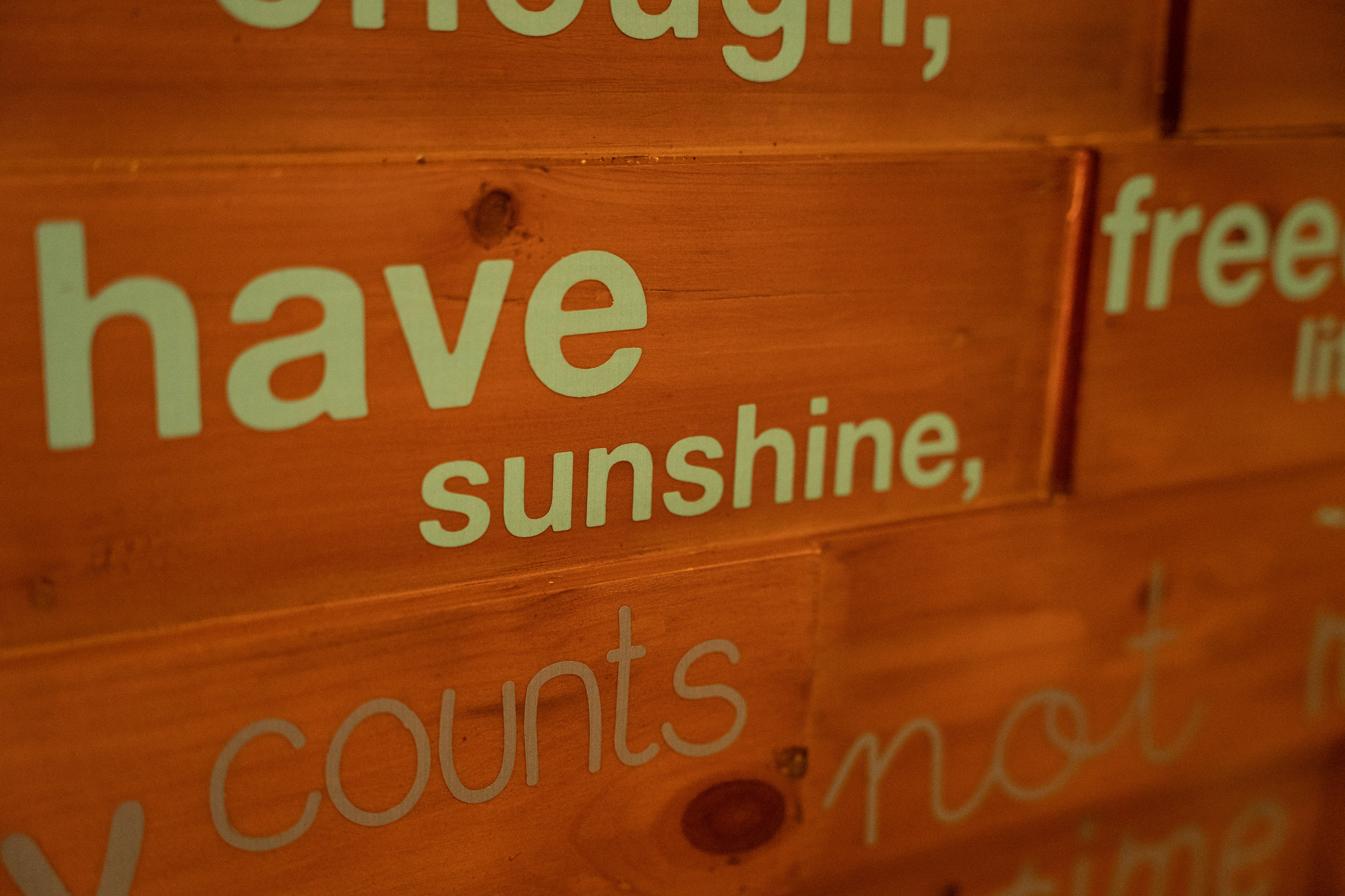 a close up of a wooden sign with words on it