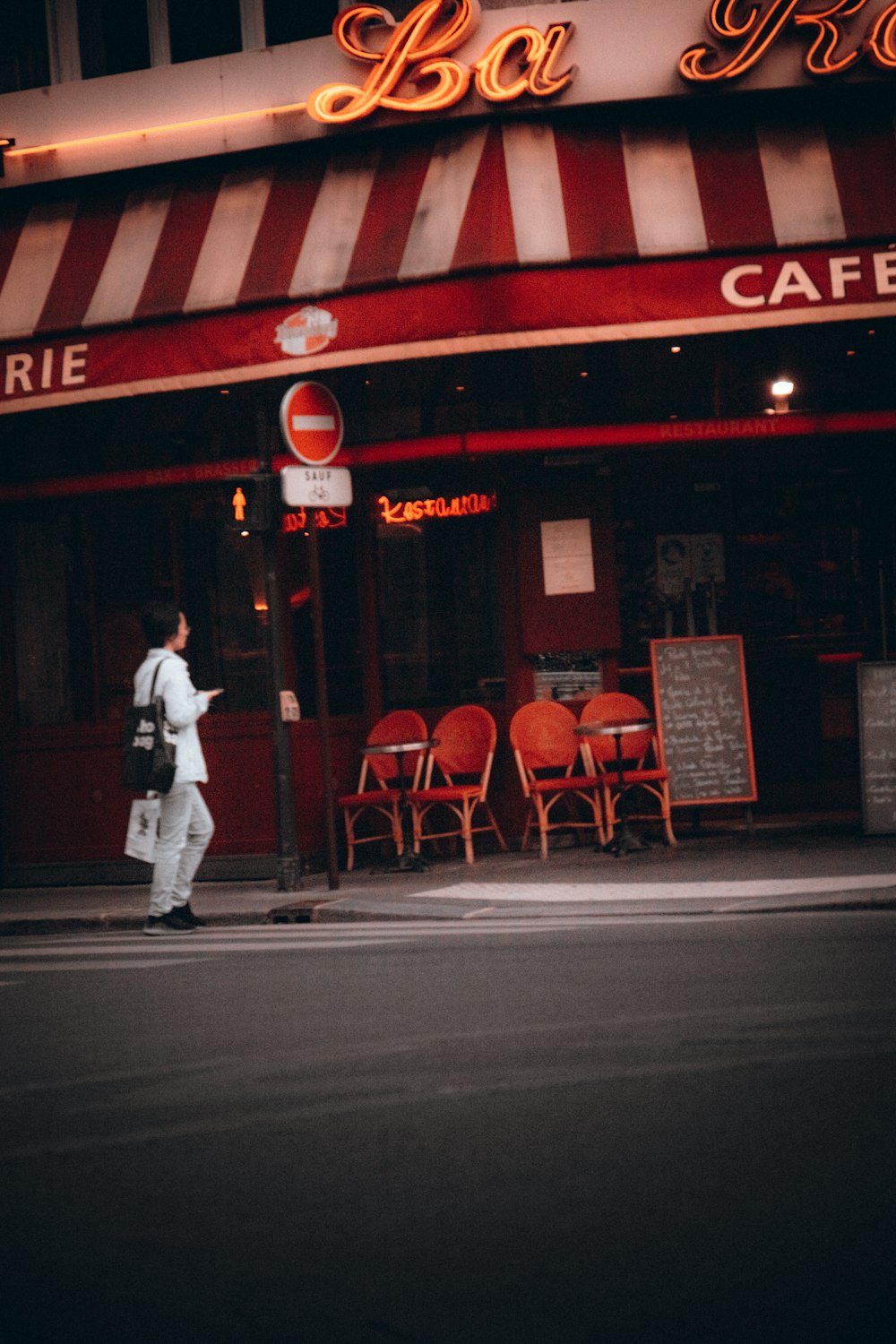 Un uomo che cammina per strada di fronte a un caffè