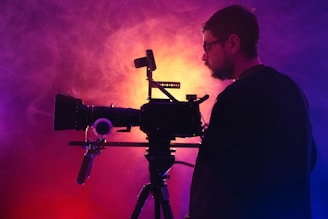 a man standing in front of a camera on a tripod