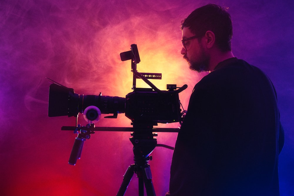 a man standing in front of a camera on a tripod