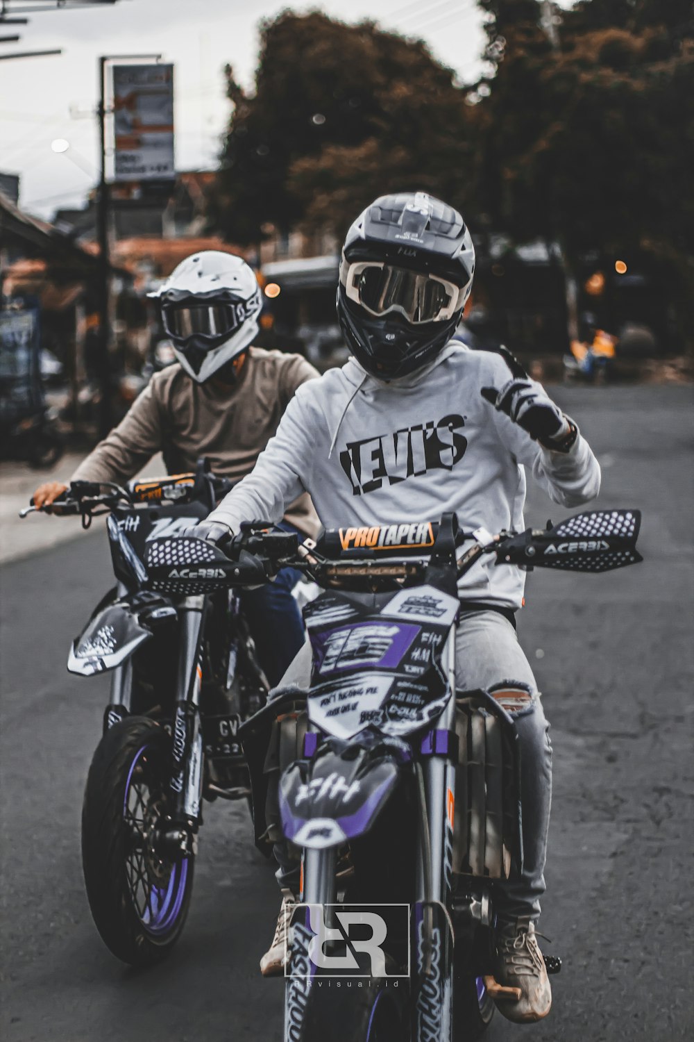 a couple of people riding on the back of motorcycles