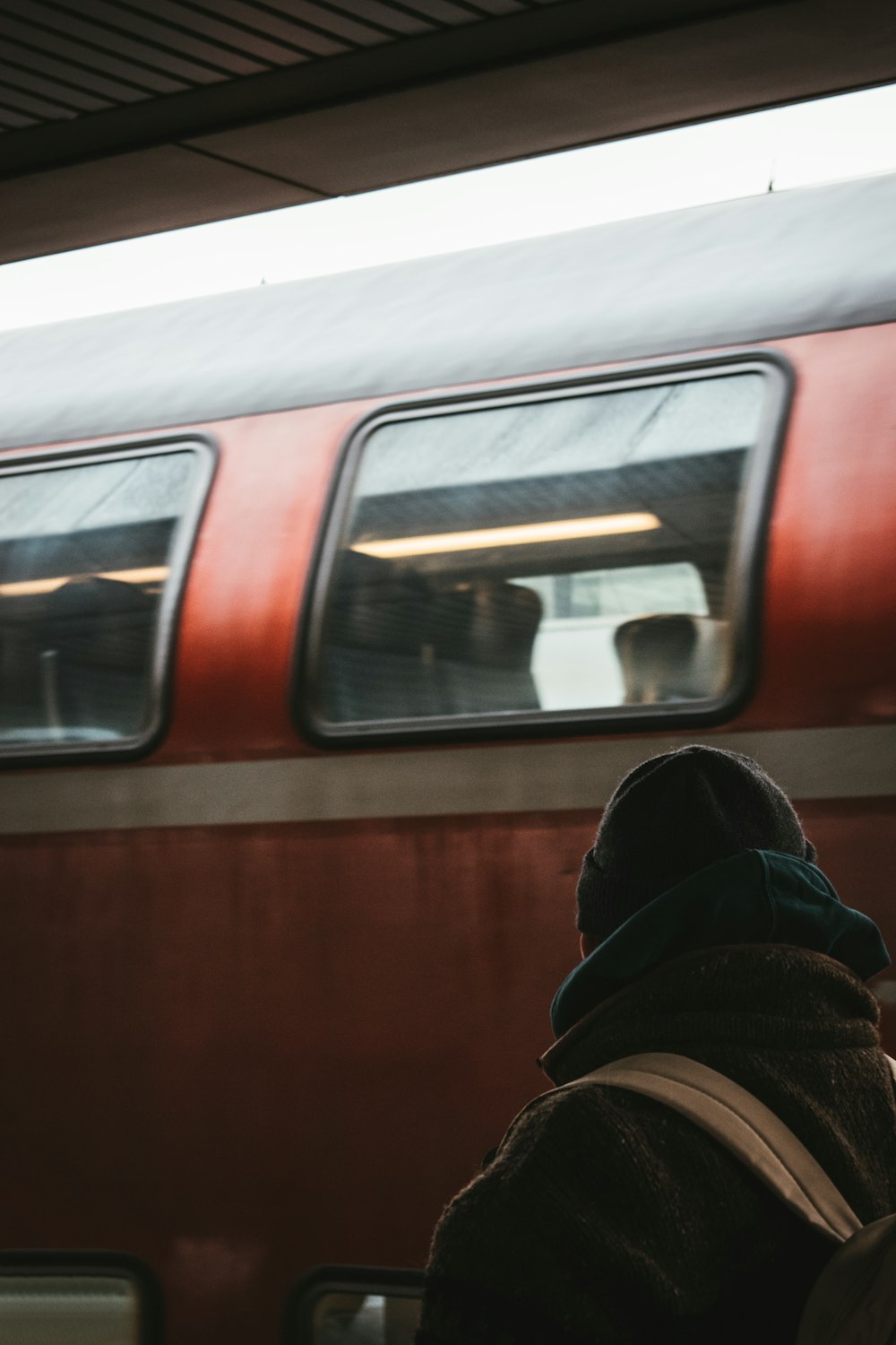 a person standing in front of a red train