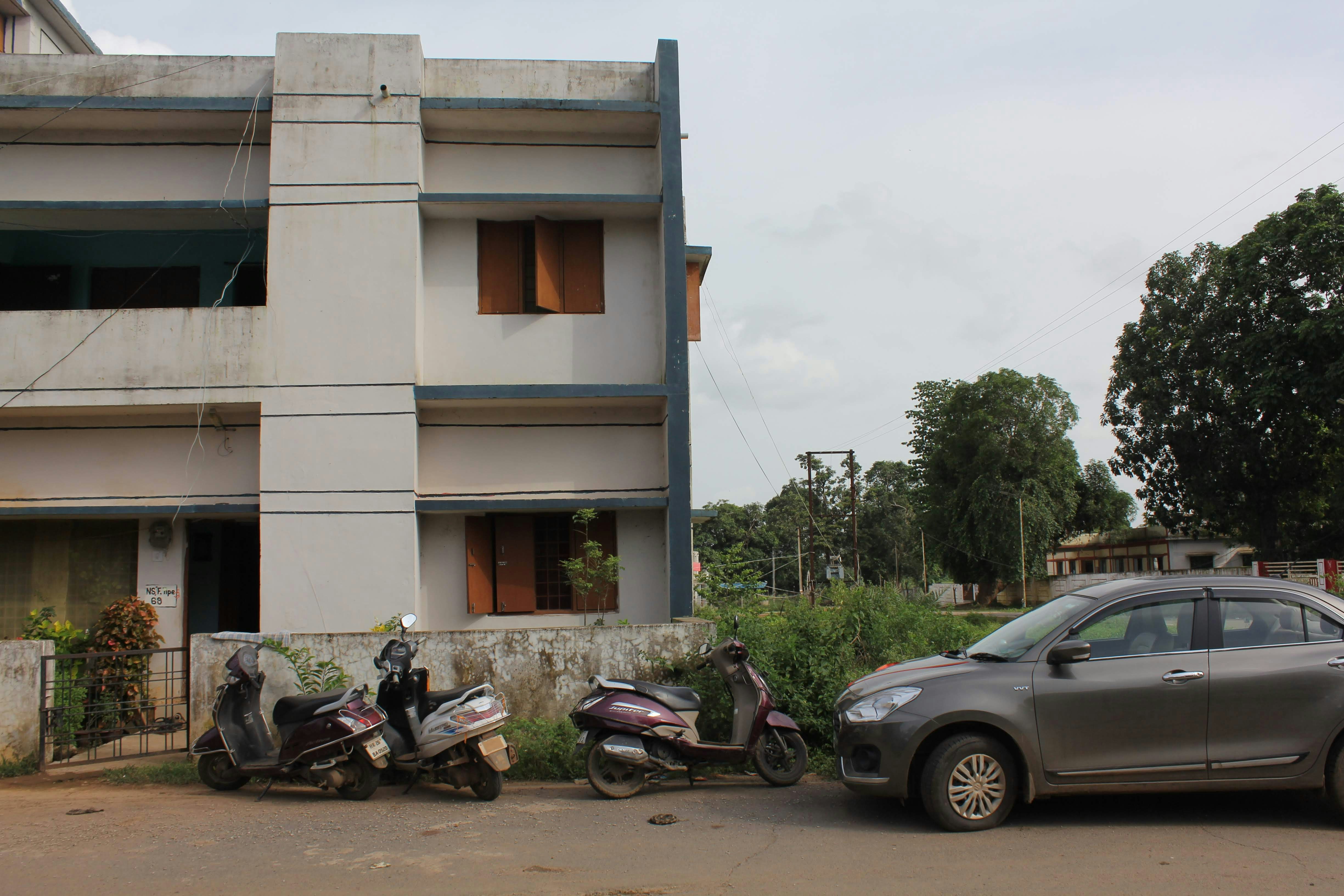 two motorcycles parked next to a car in front of a building