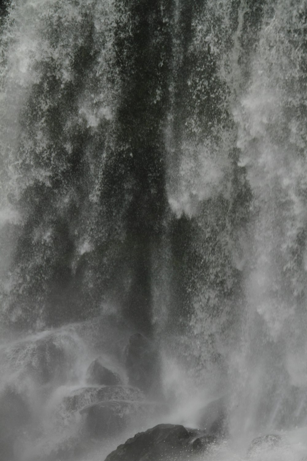 a man riding a surfboard in front of a waterfall