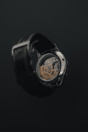 a close up of a watch on a black surface
