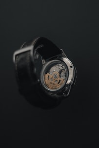 a close up of a watch on a black surface