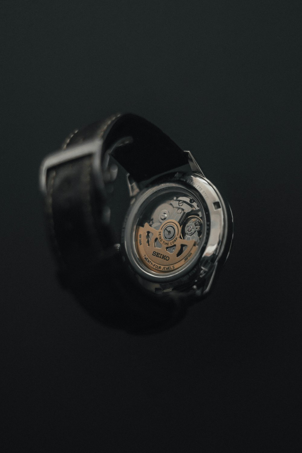 a close up of a watch on a black surface