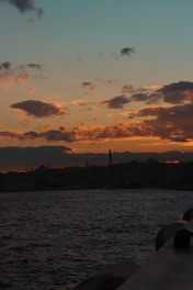 A scenic view of Istanbul's skyline at sunset with a silhouette of a traveler.