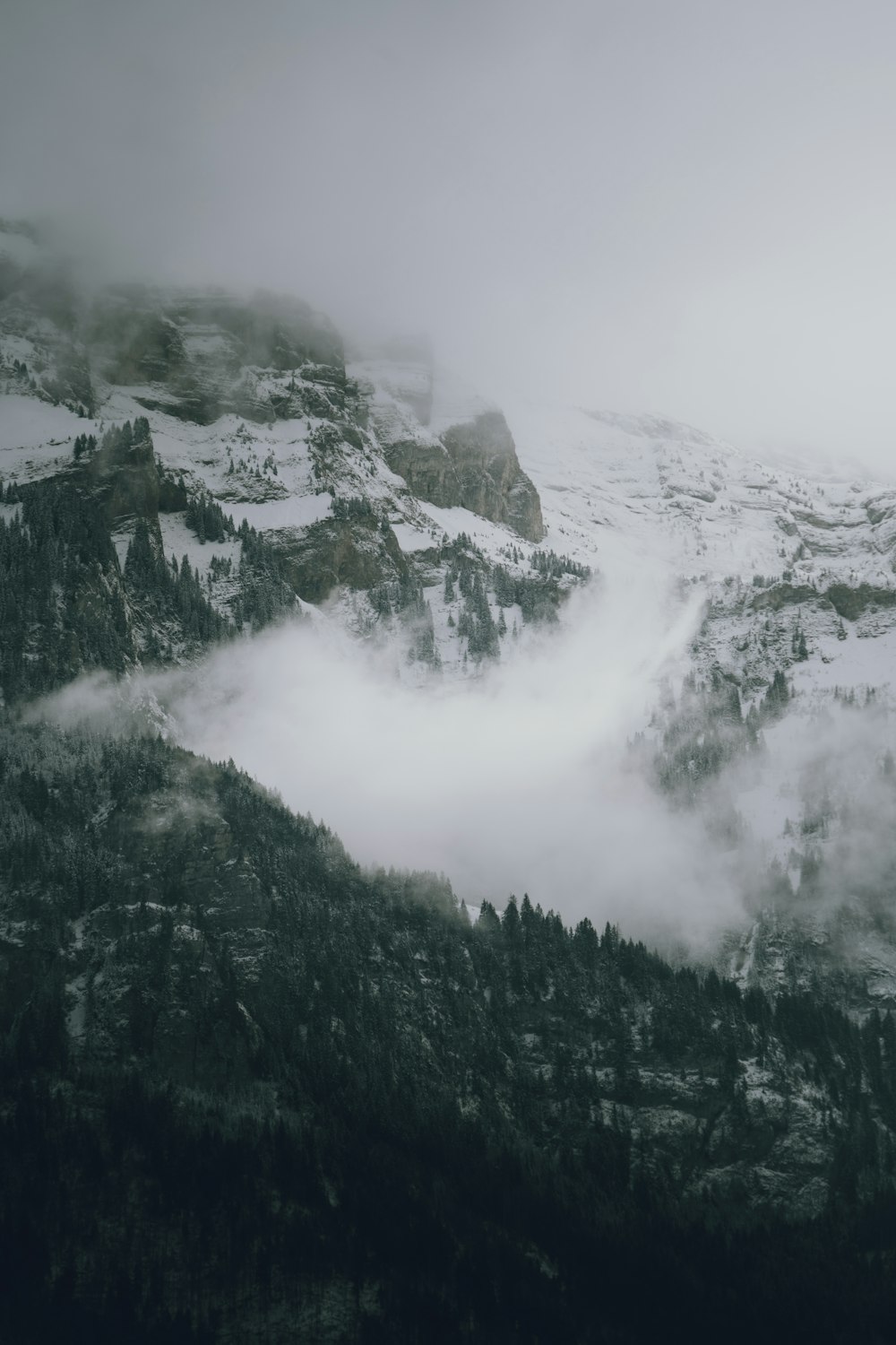 a mountain covered in snow and clouds