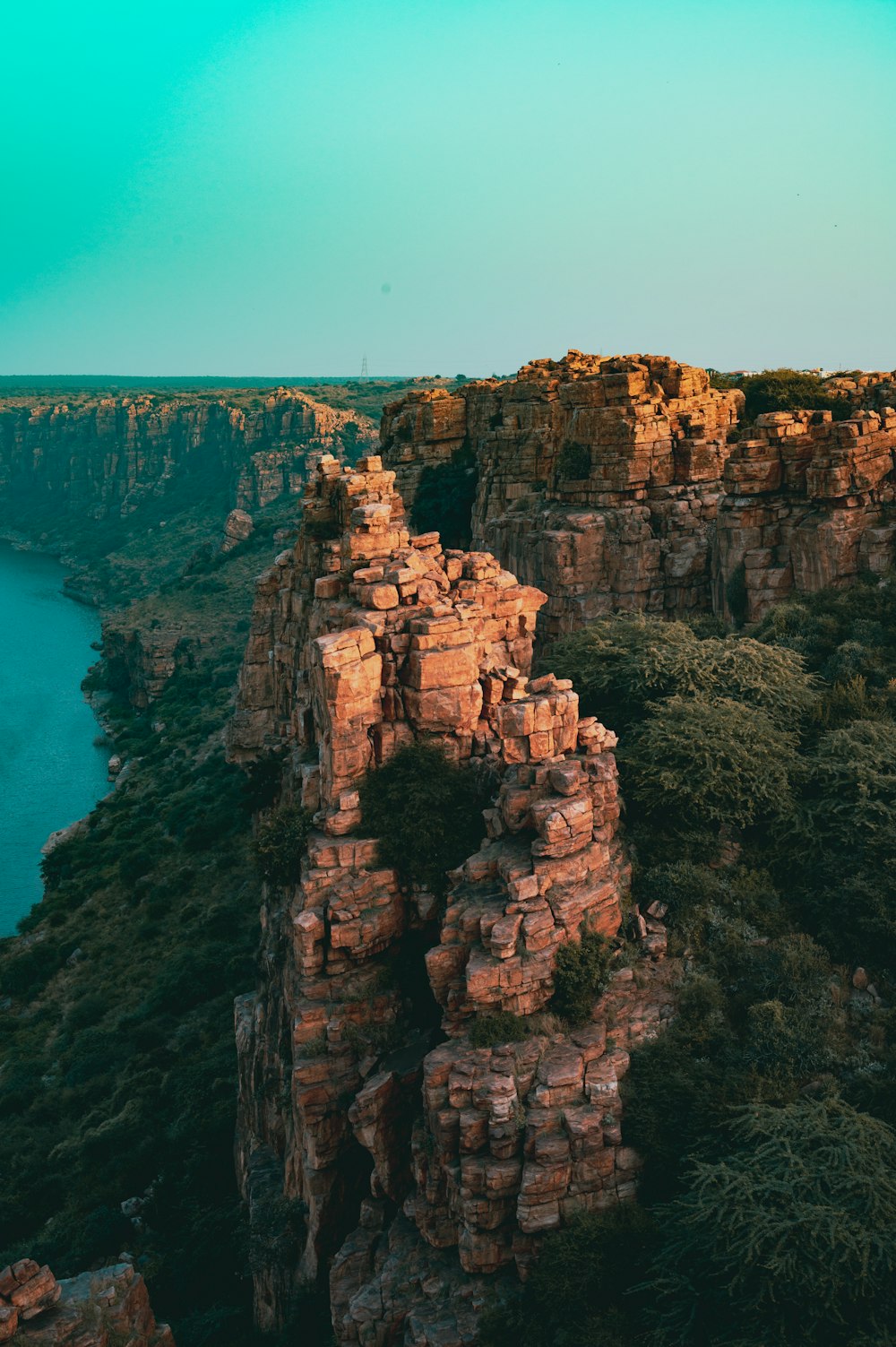 a view of a rocky cliff with a body of water in the background