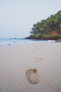a person's foot prints in the sand on a beach