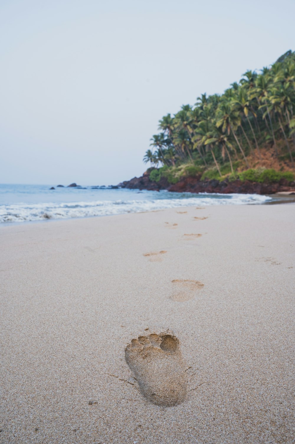 les empreintes de pieds d’une personne dans le sable sur une plage