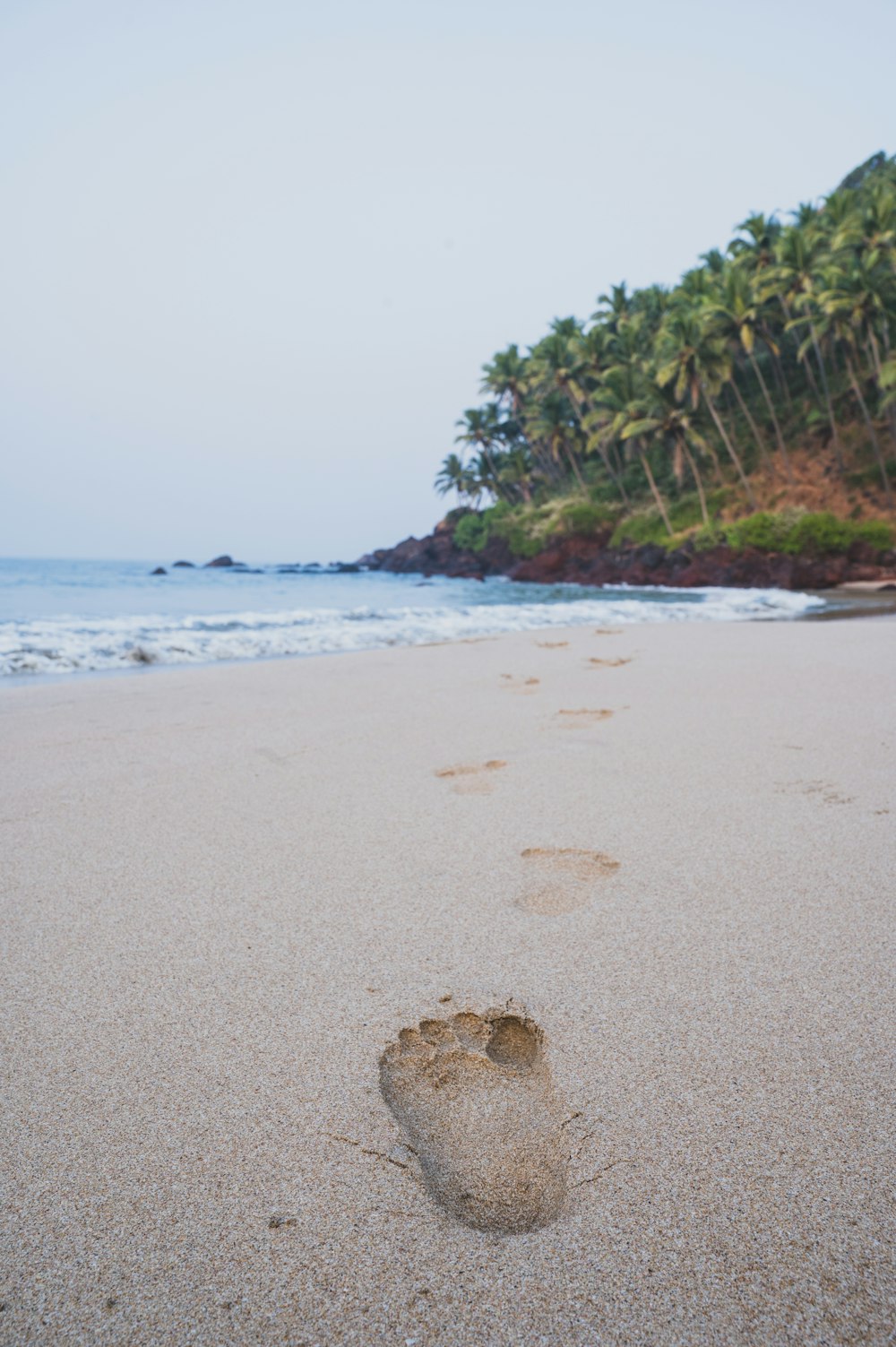 a person's foot prints in the sand on a beach