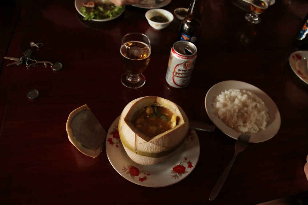 a wooden table topped with plates and bowls of food