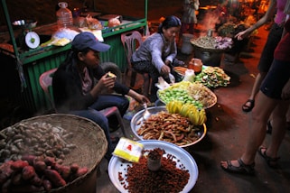 a group of people sitting around a table filled with food