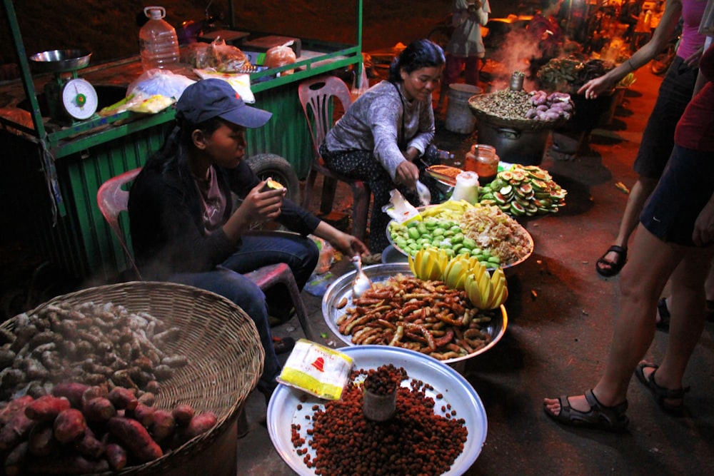 a group of people sitting around a table filled with food