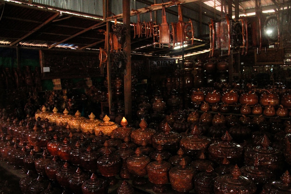 a room filled with lots of brown vases