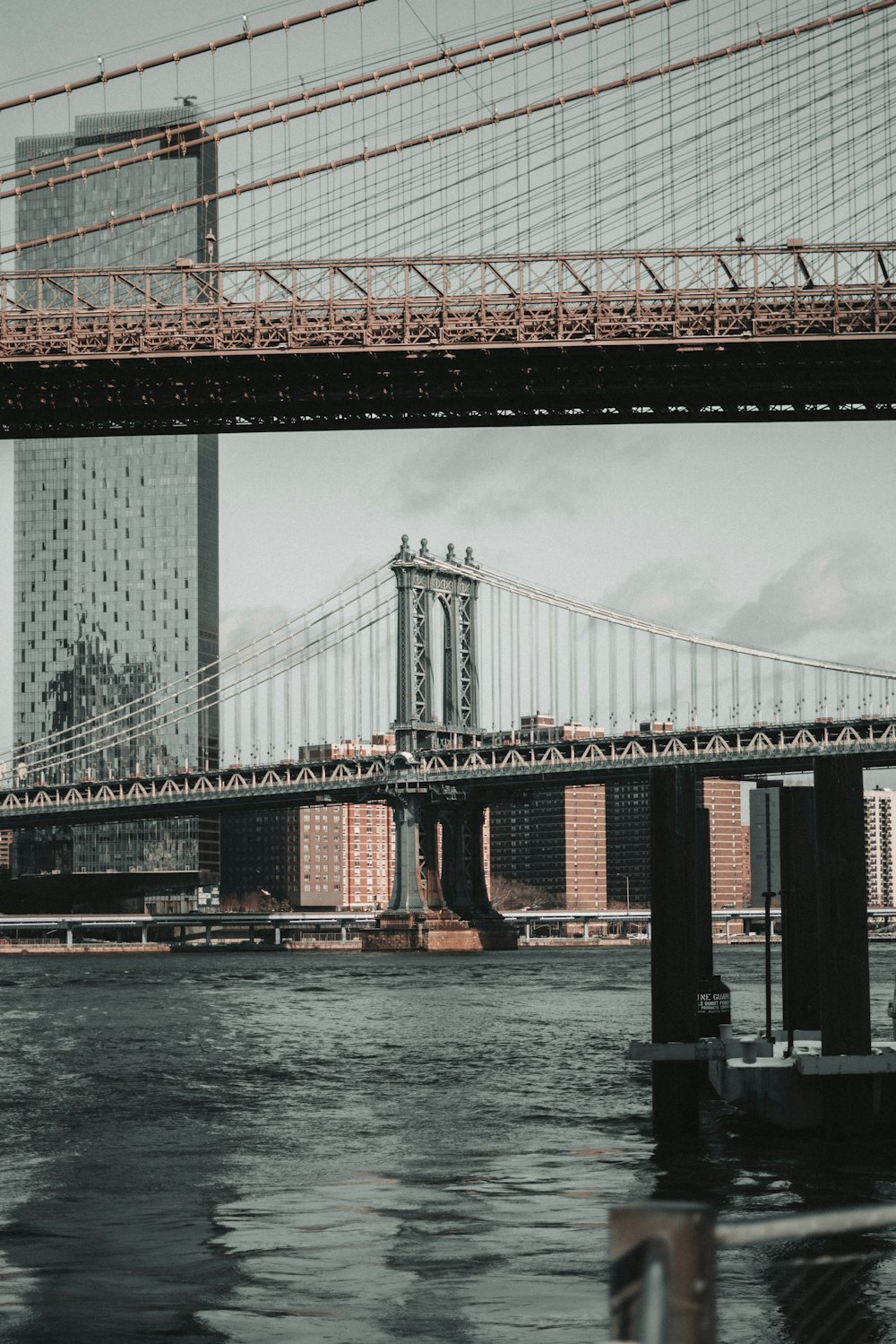 a bridge over a body of water with a tall building in the background