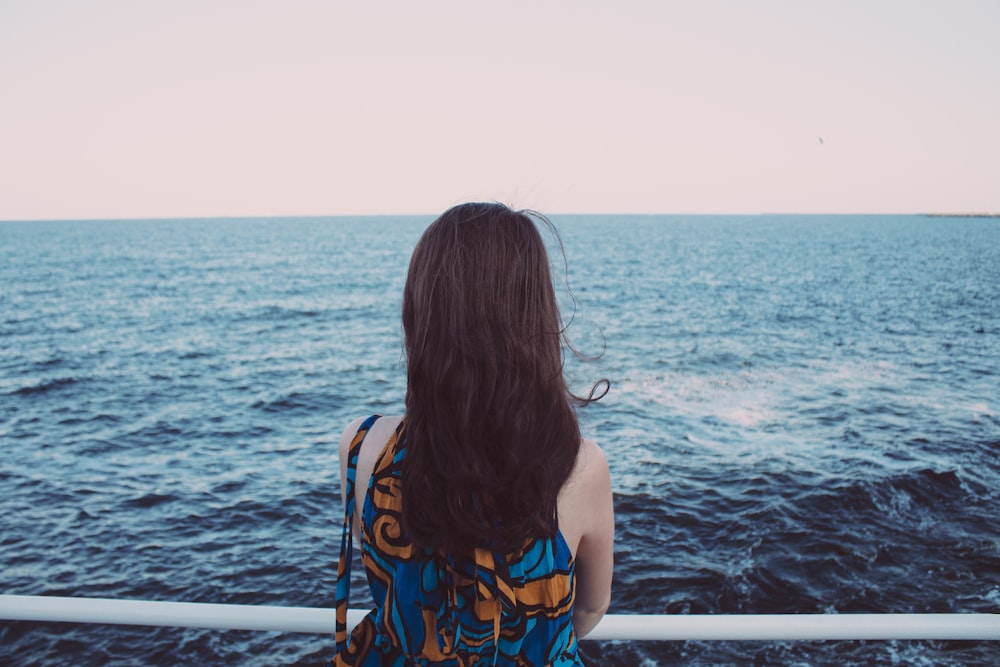 a woman standing on a boat looking out at the ocean