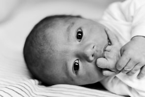 a close up of a baby laying on a bed