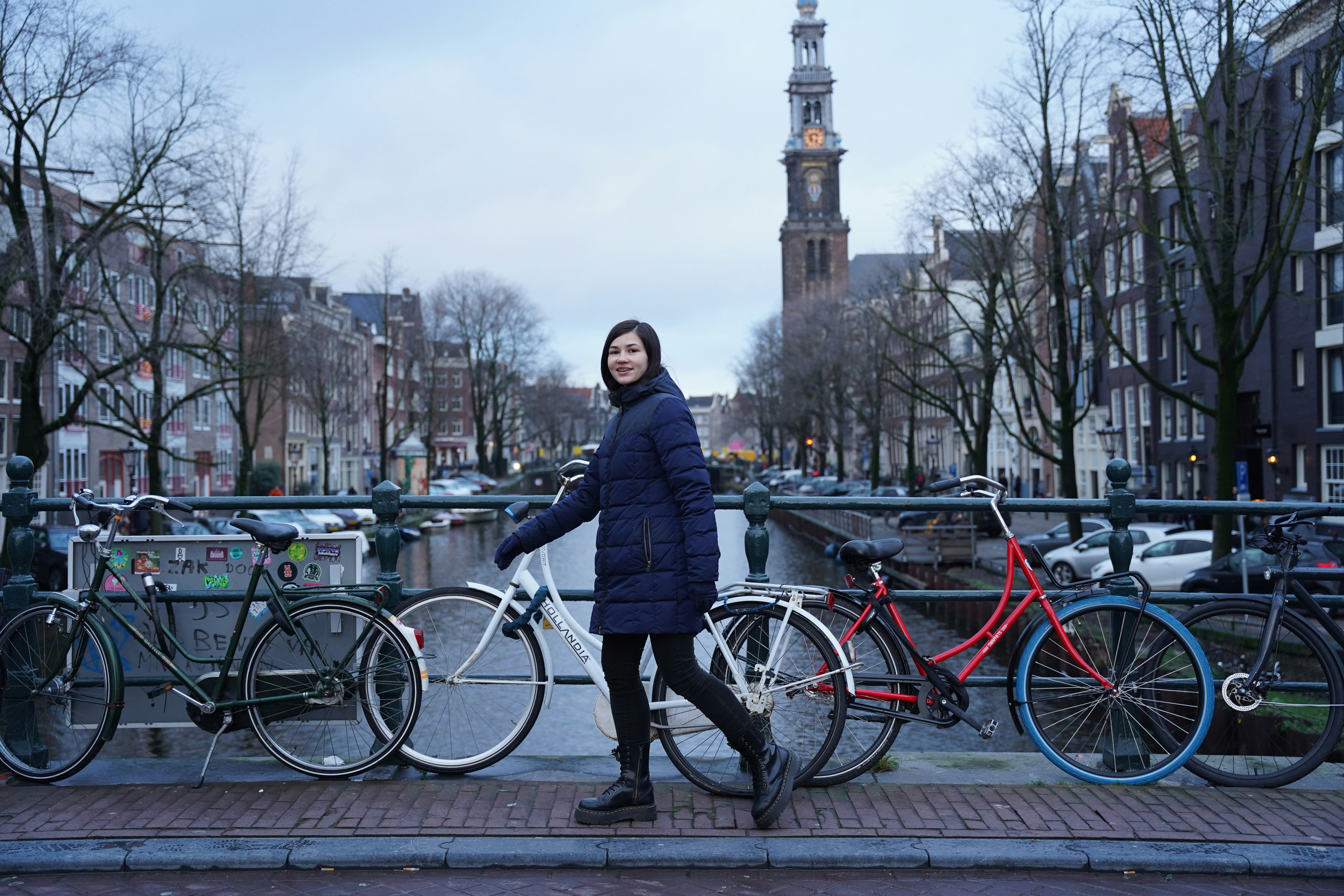 a woman standing next to a bunch of bikes