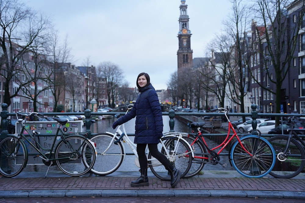 a woman standing next to a bunch of bikes