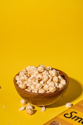 a bowl of popcorn sitting on top of a yellow table