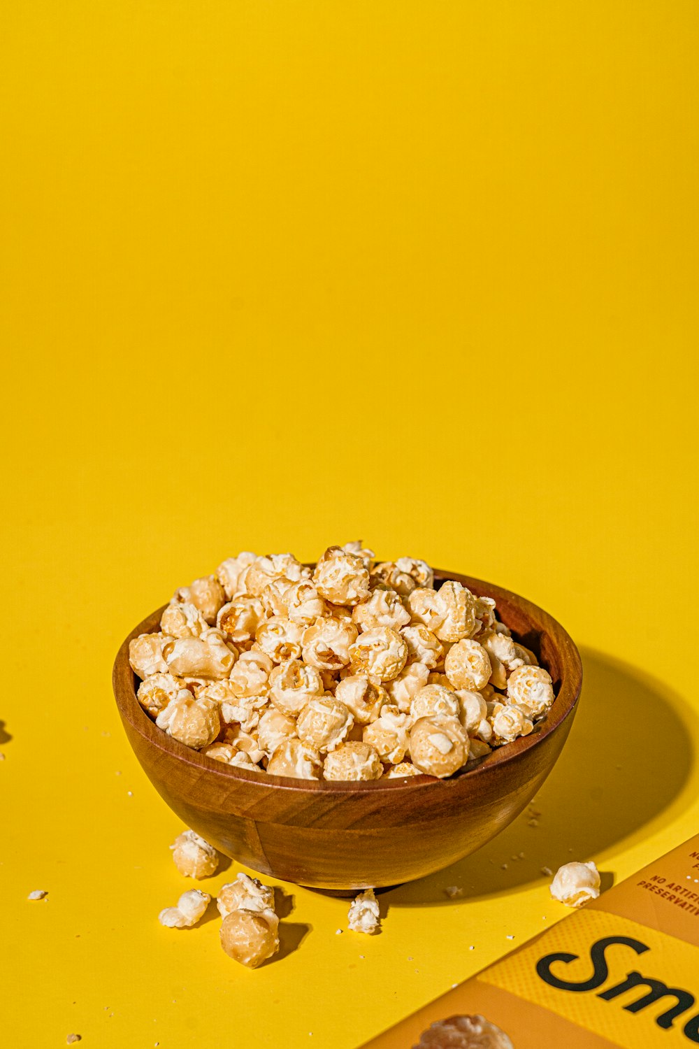 a bowl of popcorn sitting on top of a yellow table