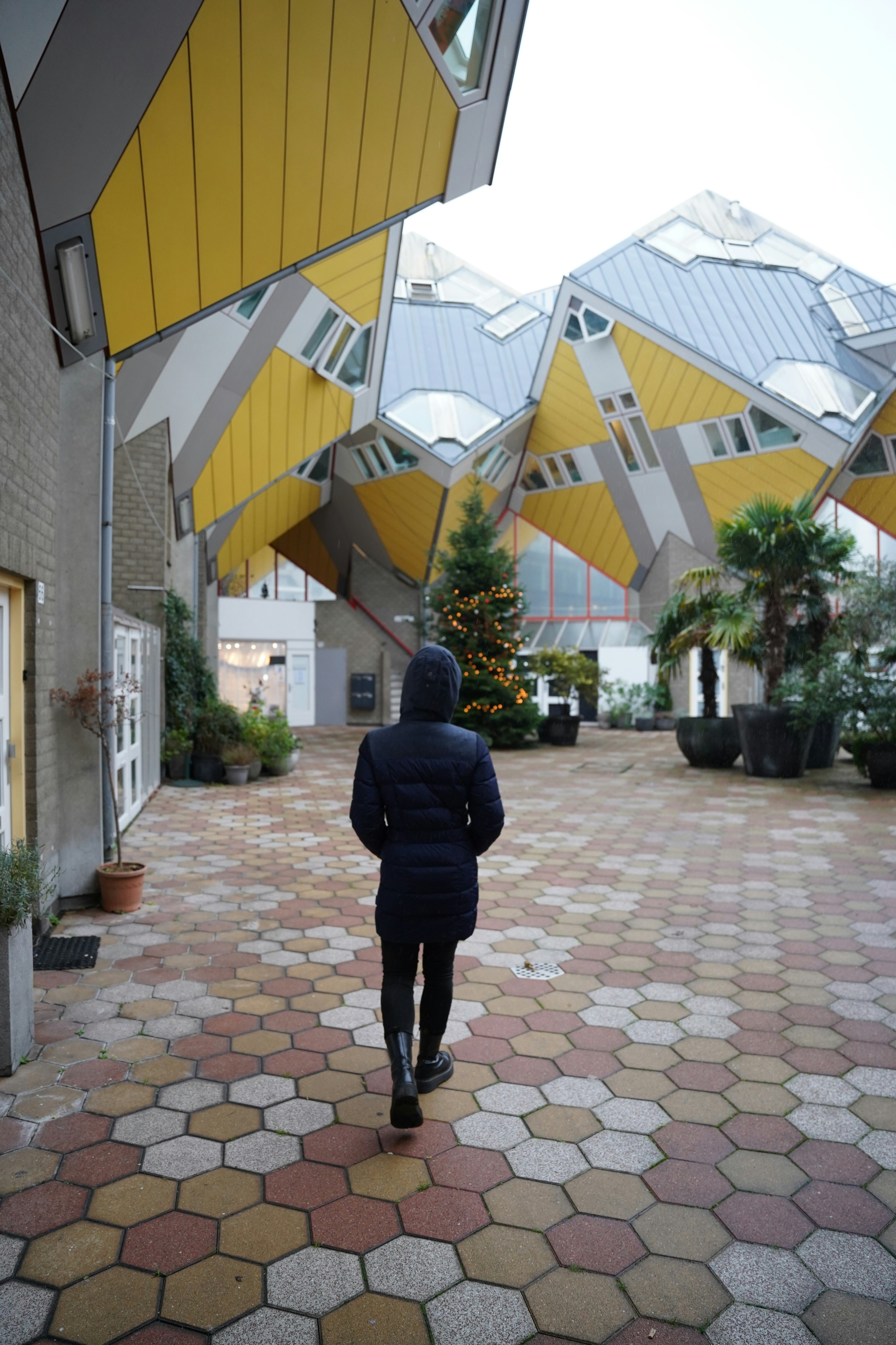 a person in a blue jacket is walking through a courtyard