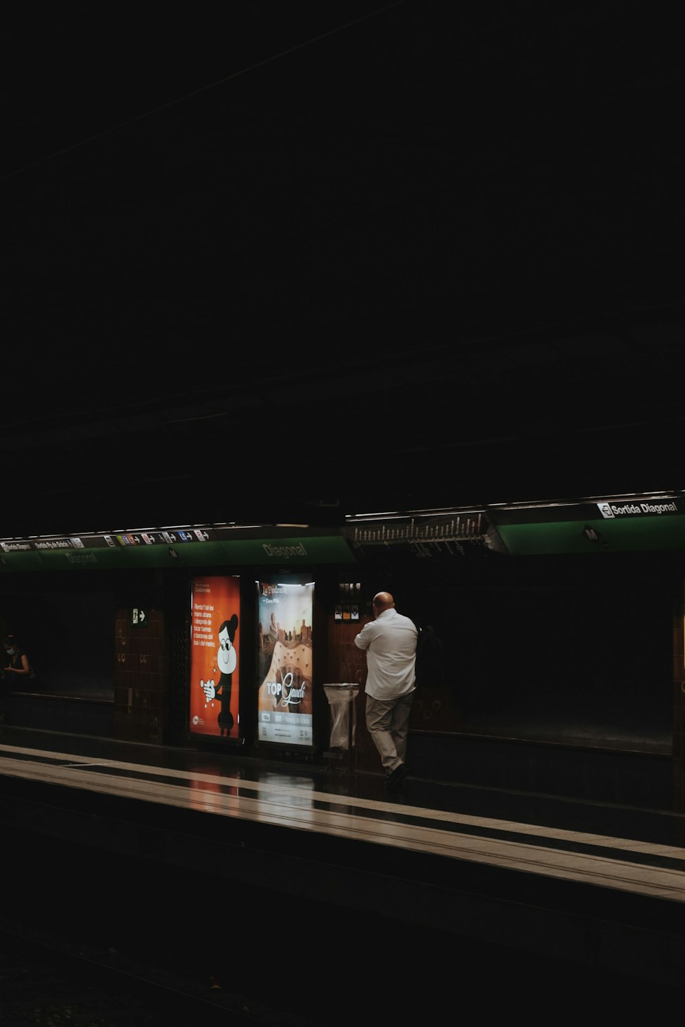 a man standing on a train platform next to a train