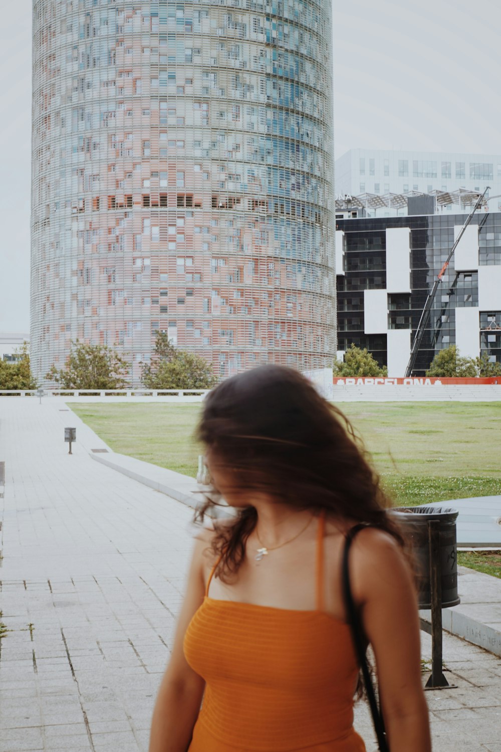 a woman in an orange dress walking down a sidewalk