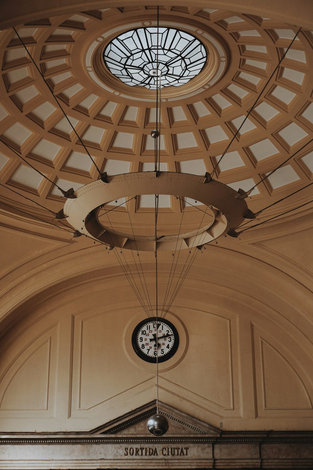 a clock hanging from the ceiling of a building
