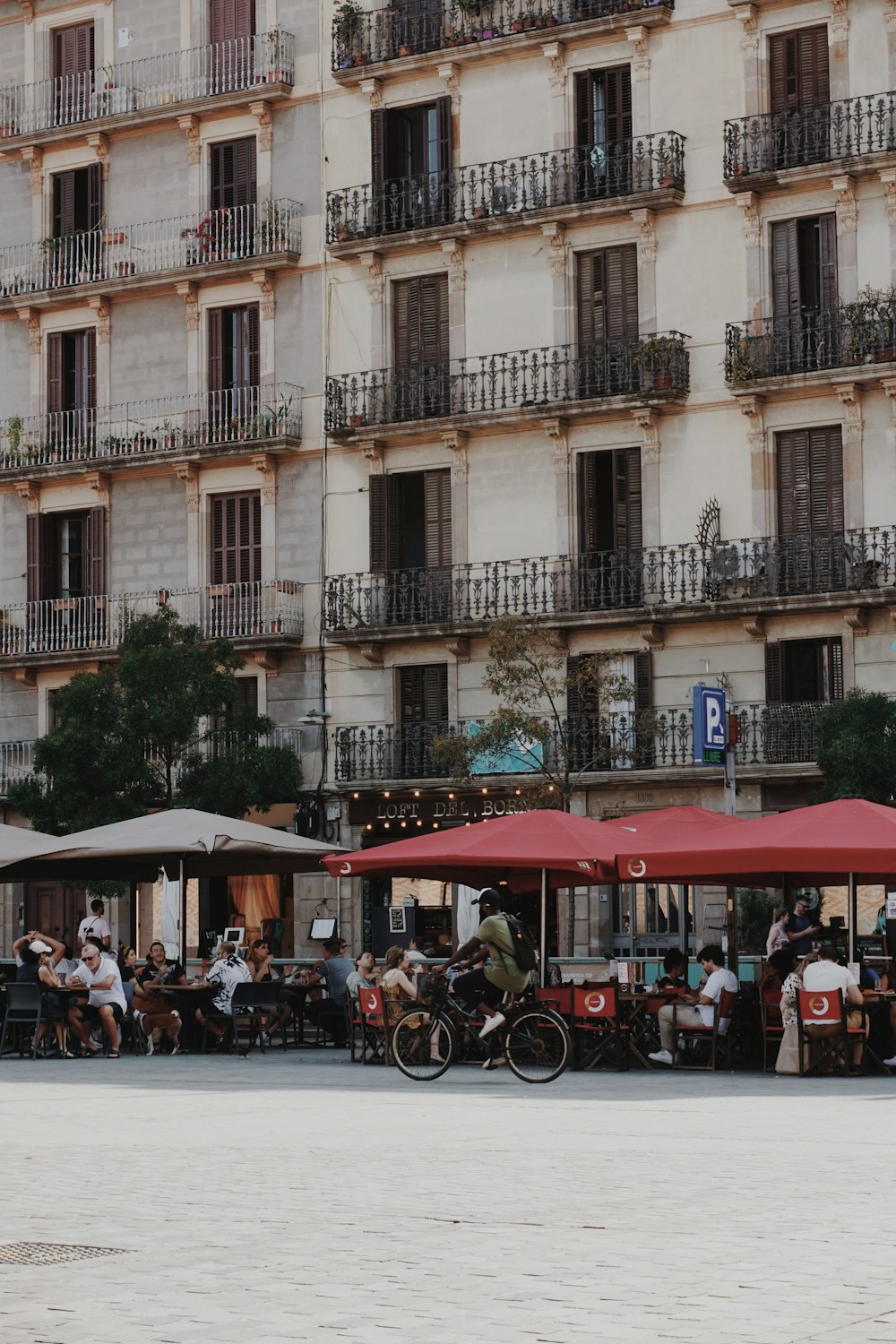 Un grupo de personas sentadas en mesas frente a un edificio