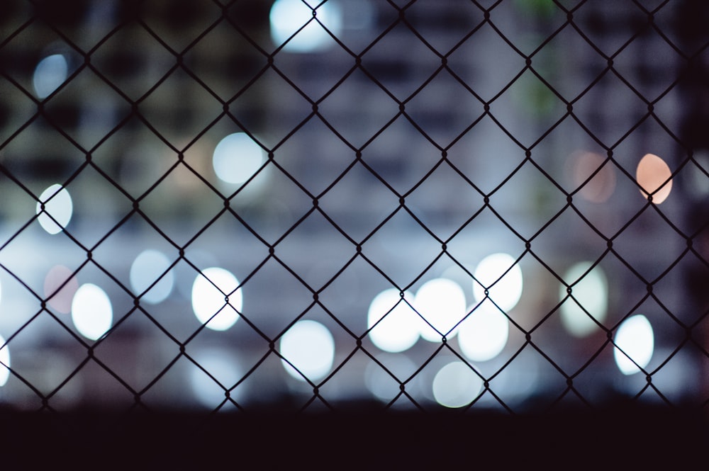 a view of a city through a chain link fence