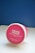 A round container with a pink lid featuring the brand name 'DOUGH LICIOUS' in bold white letters. Below the name, there are phrases like 'edible and bakeable cookie-dough' and '#lovelocal'. It rests on a white surface with a blue background.