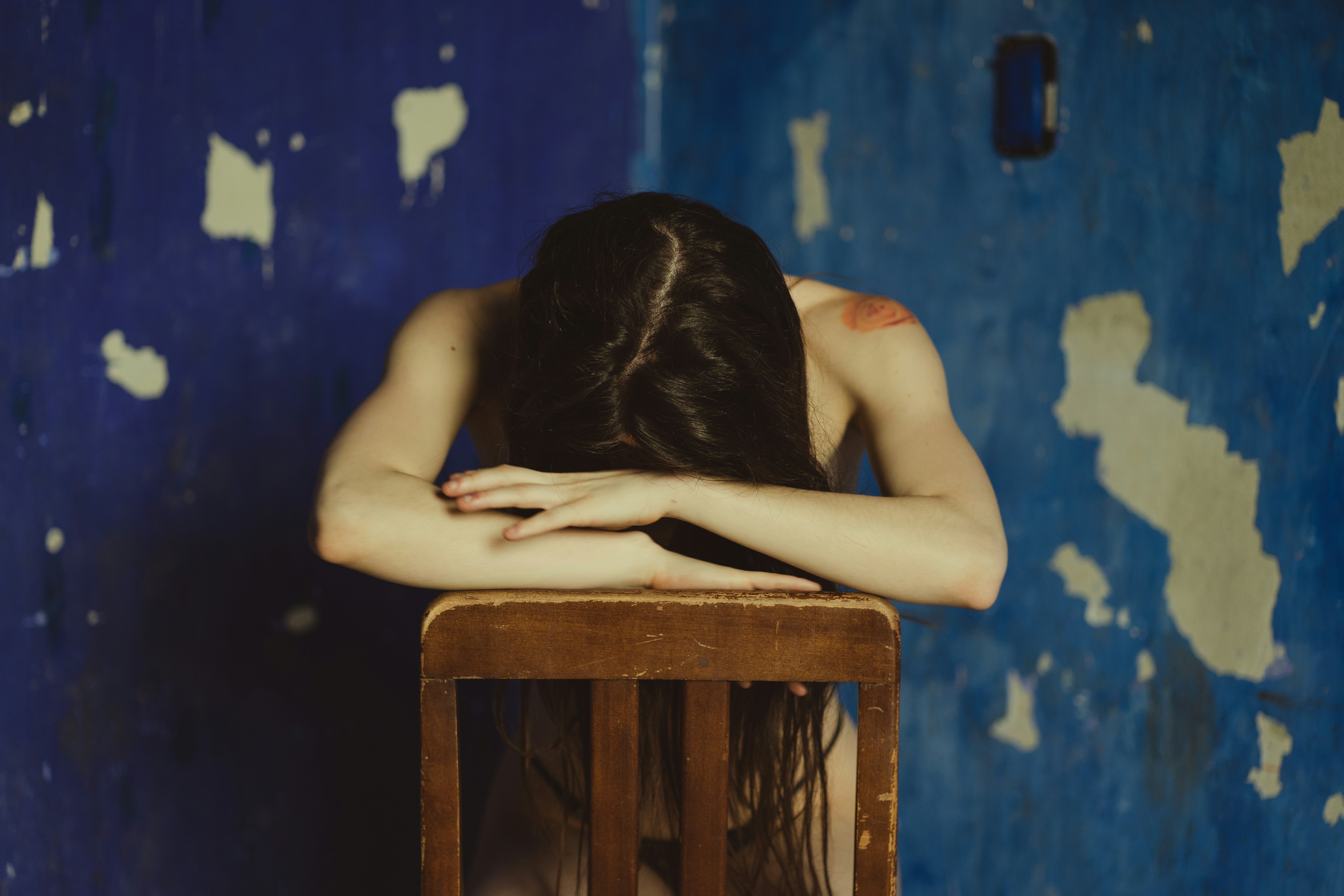 a woman sitting in a chair with her head on her hands