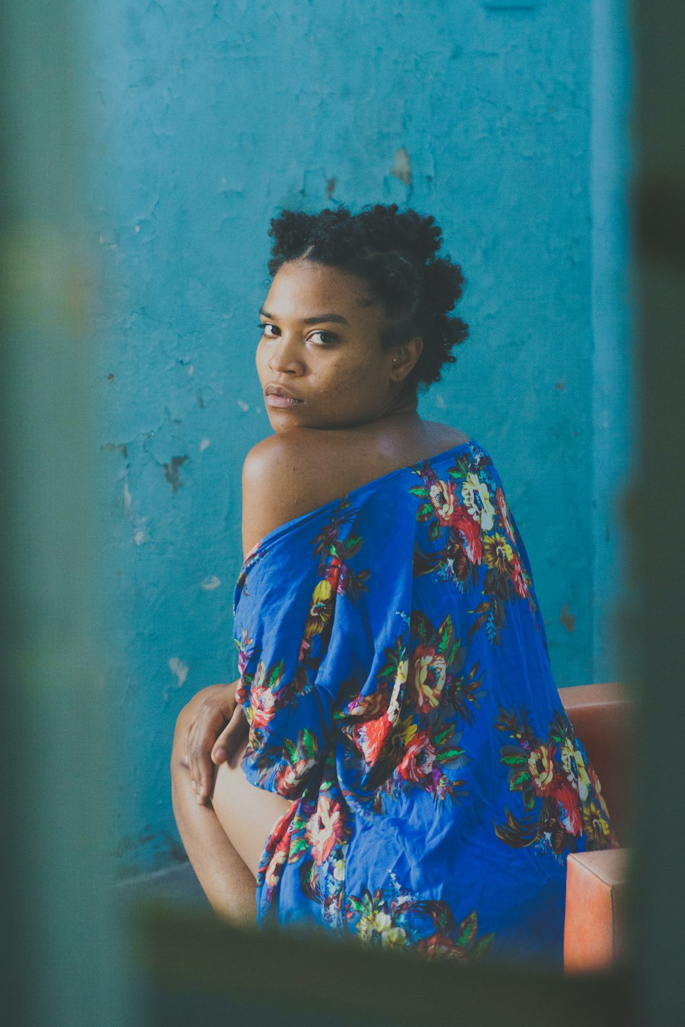 a woman sitting on a bench in front of a blue wall