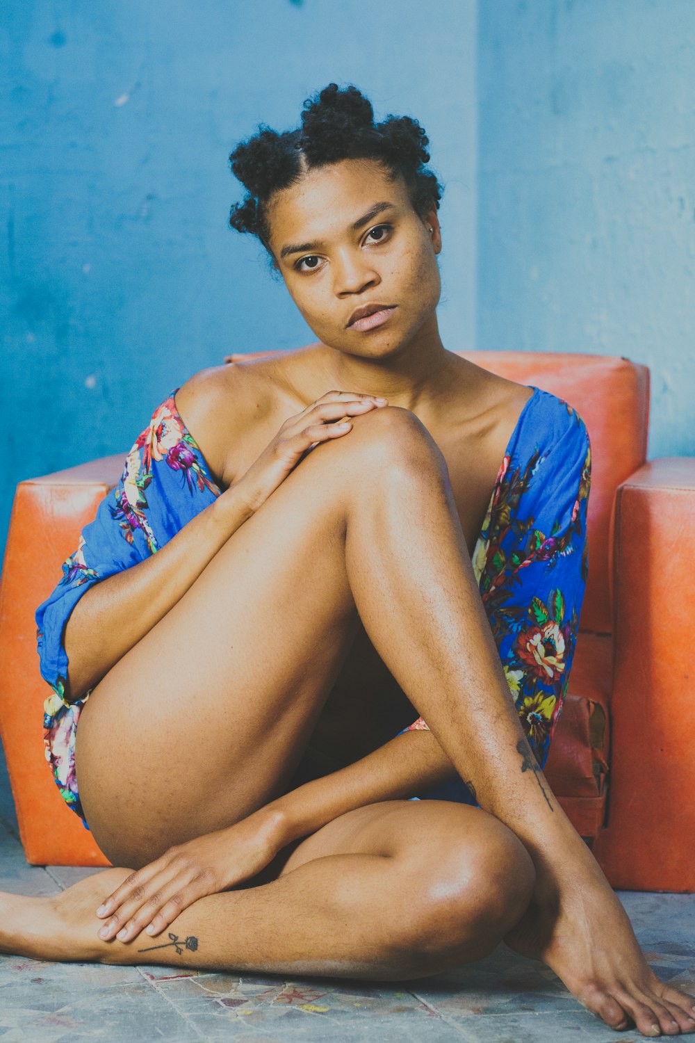 a woman in a blue dress sitting on a couch