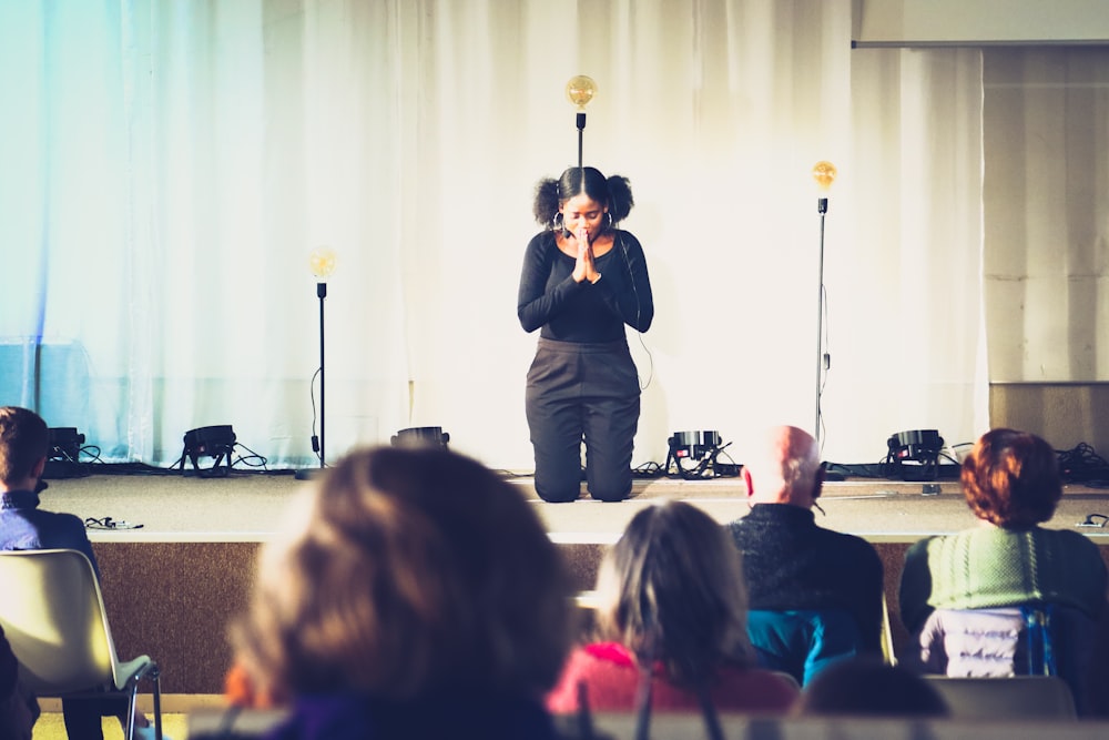 a woman standing on a stage in front of a crowd