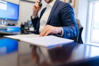 a man sitting at a desk writing on a piece of paper