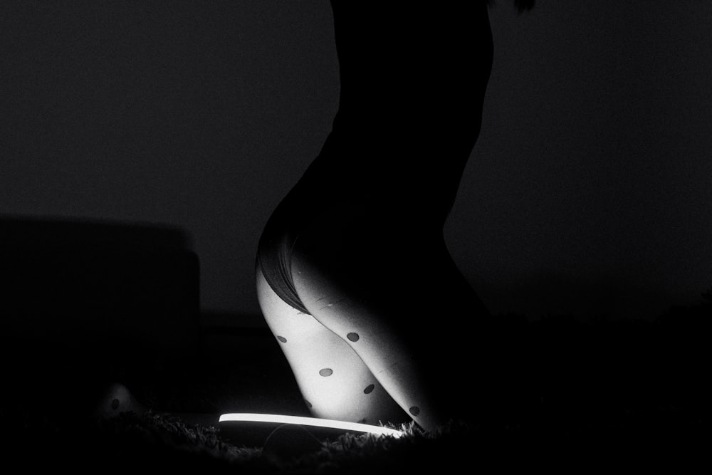 a black and white photo of a woman's legs in the dark