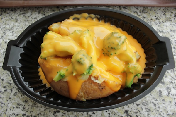 A baked potato covered in cheese and broccoli