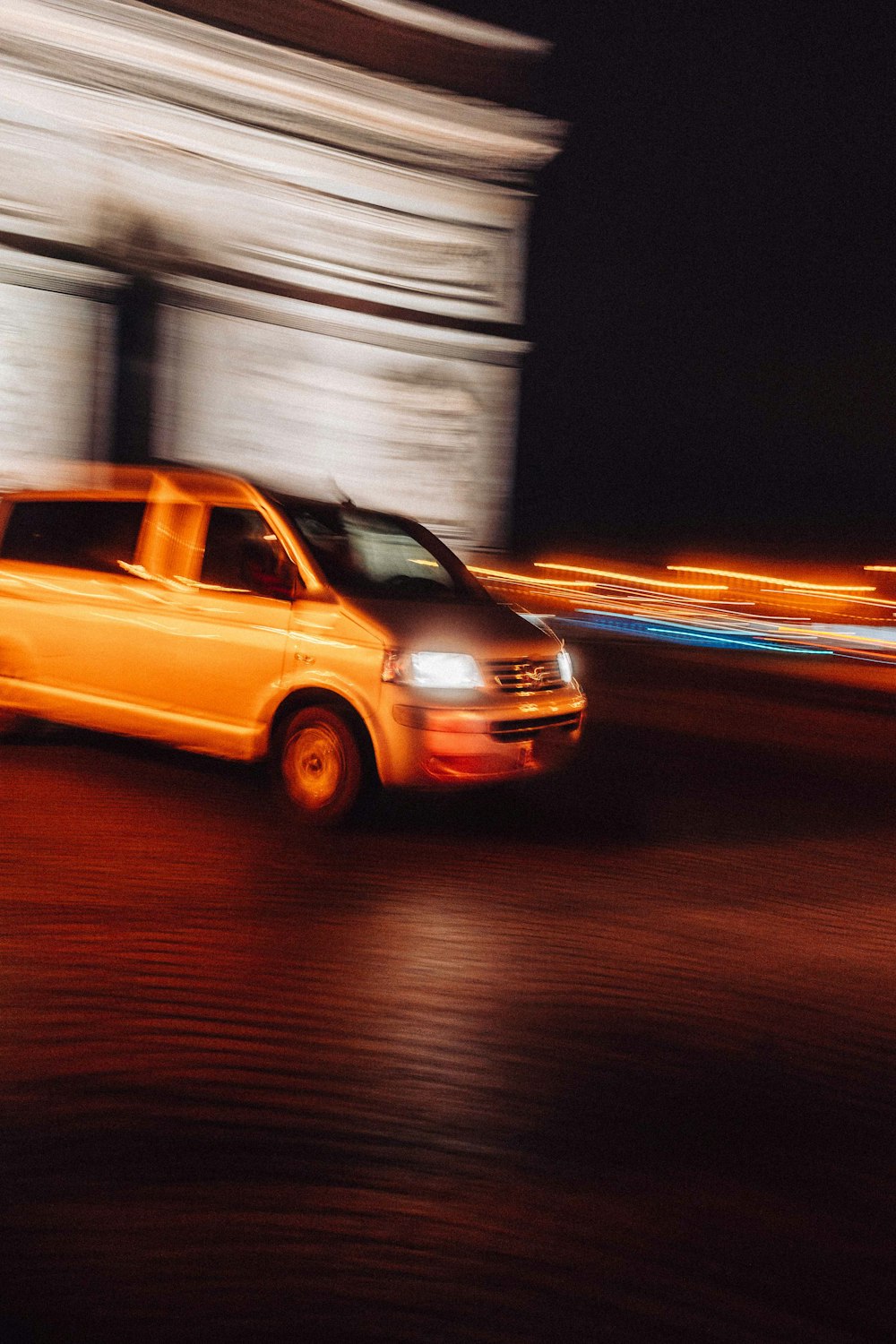 a yellow taxi driving down a street next to a tall building