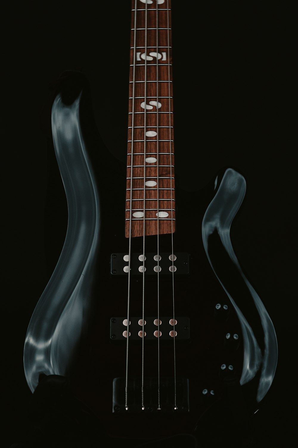 a black electric guitar with a black background