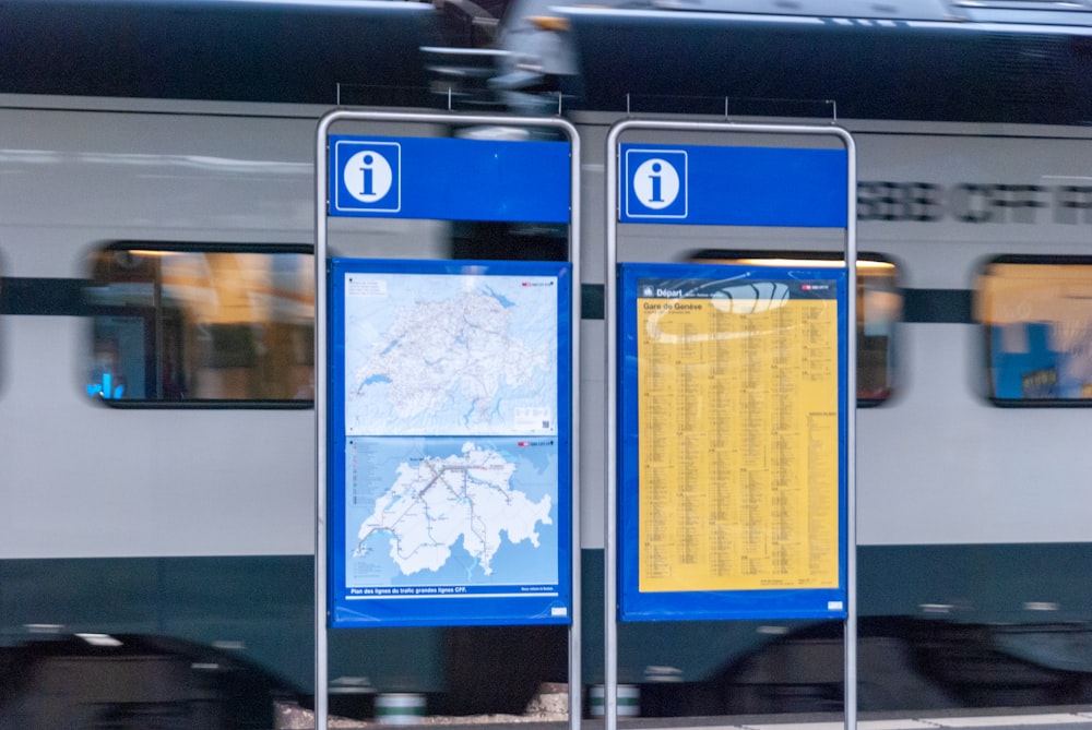 a train traveling past a train station next to a platform