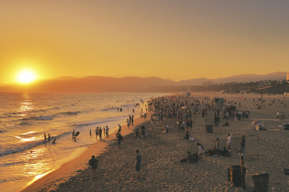 a group of people standing on top of a sandy beach