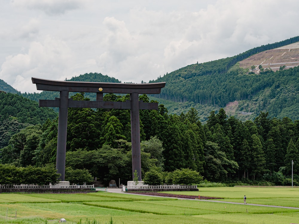 a large gate in the middle of a lush green field