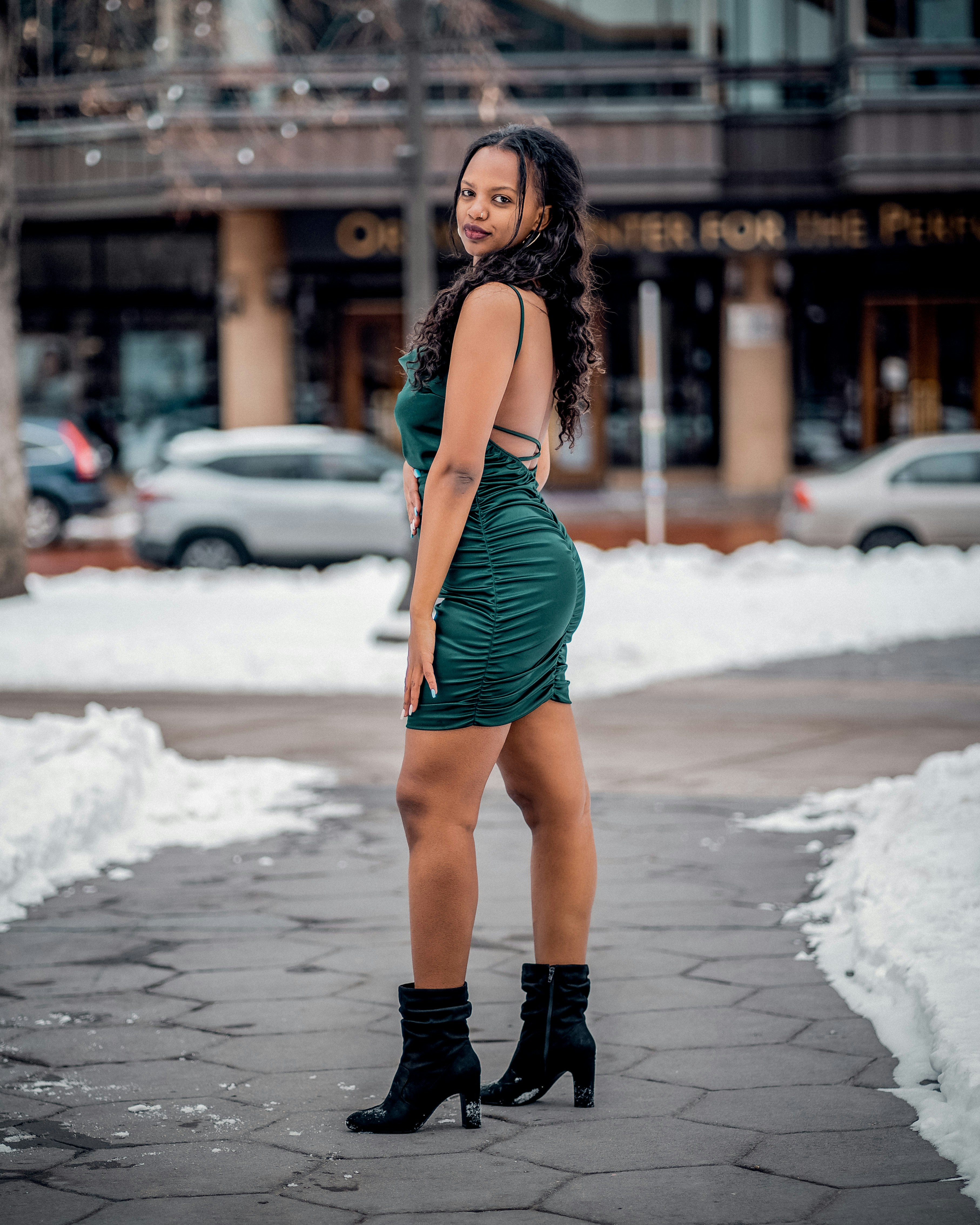 Una mujer con un vestido verde parada en una acera