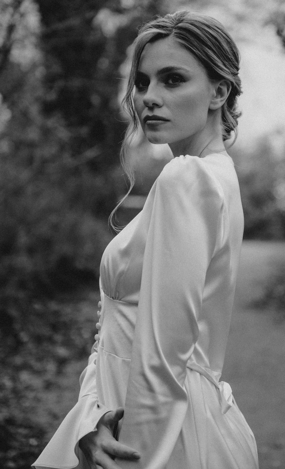 a black and white photo of a woman in a dress